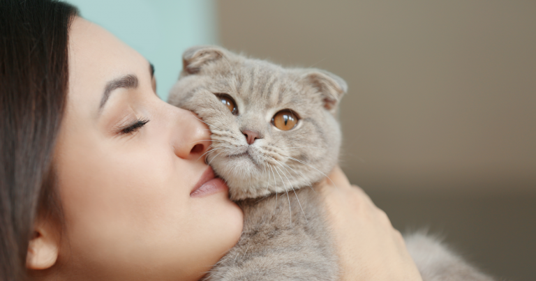 Young woman kissing her cat